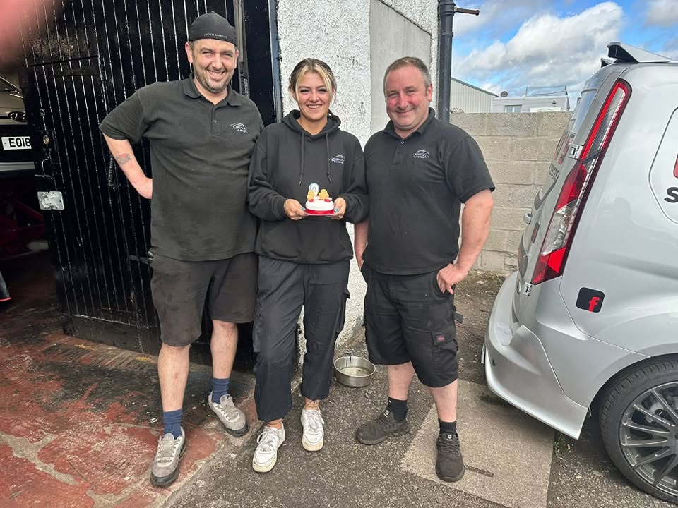 The CJ Auto's team — friendly staff smiling outside the garage